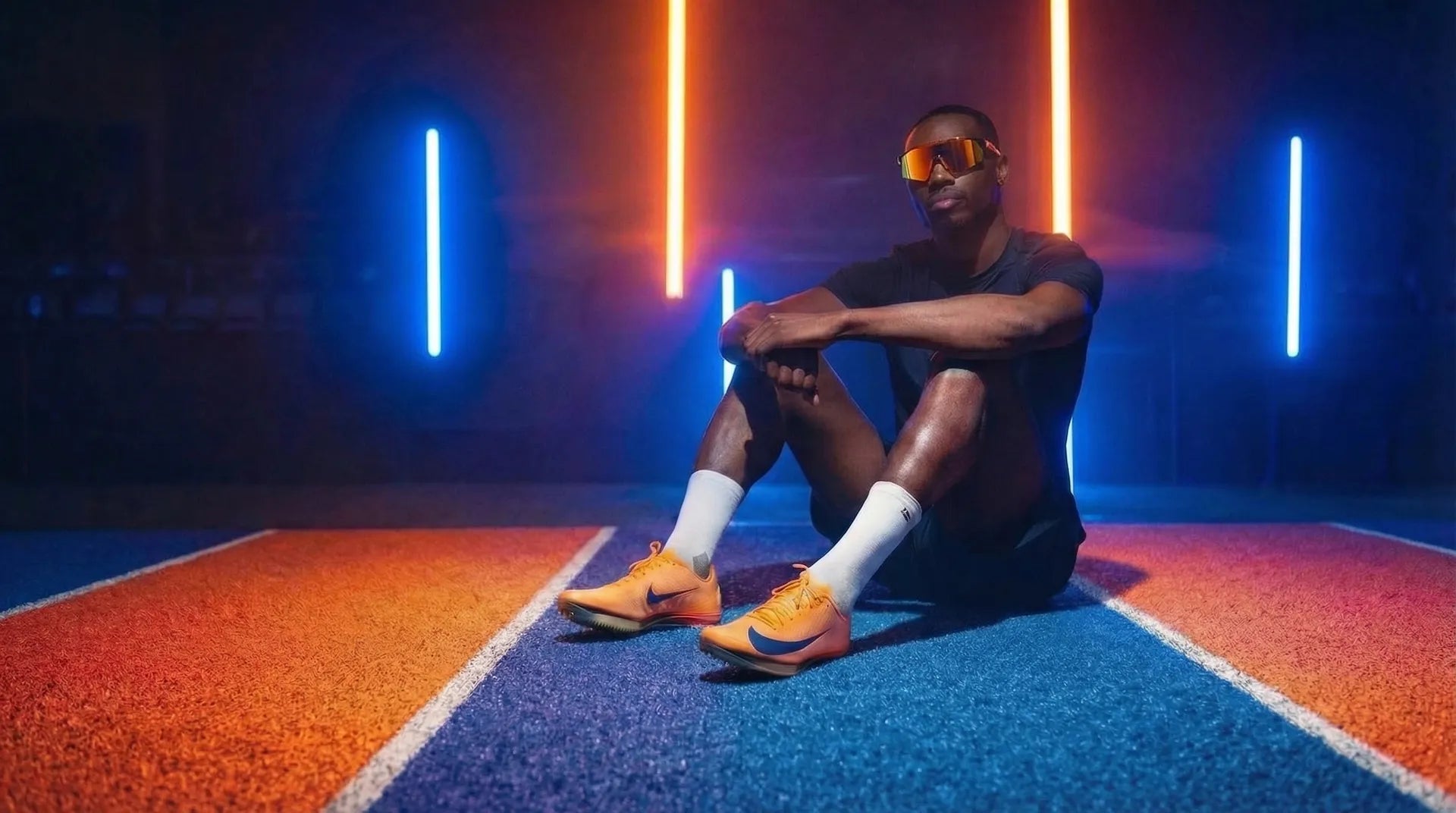 Atleta con scarpe chiodate Nike su pista di atletica - Maxfly scarpe da sprint